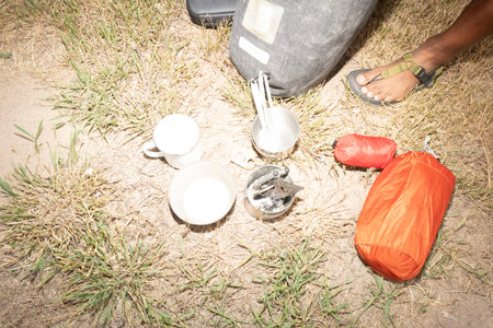 Close-up of a man pouring milk into a cup while campingの写真素材