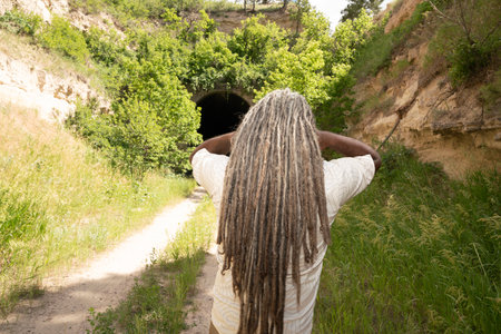 Rear view of african american girl with dreadlocks looking at a tunnelの写真素材