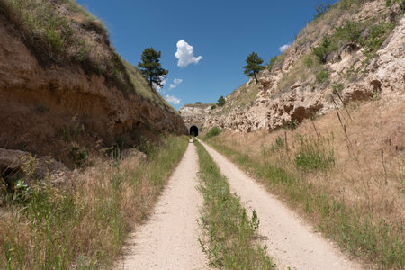 Dirt road leading to a tunnel in the sandstone cliffs.の写真素材