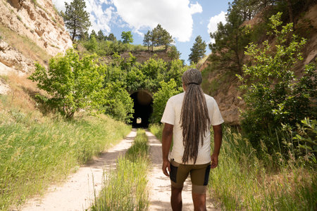 Young man with dreadlocks looking at a tunnel in the mountains.の写真素材