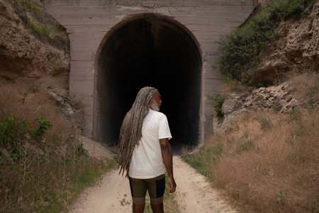 African man with dreadlocks in the middle of an old tunnel.の写真素材