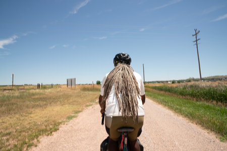 Rear view of a woman riding a motorbike in the countrysideの写真素材