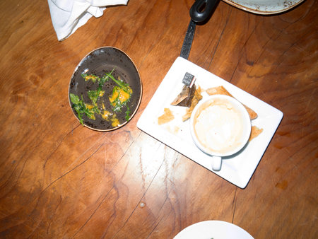 Breakfast with coffee and fried eggs in a bowl on a wooden tableの写真素材