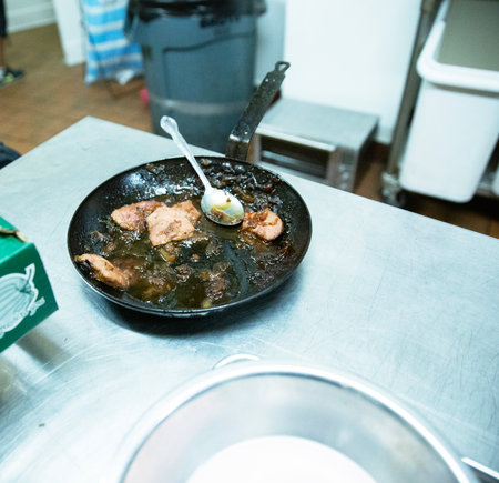 Fried chicken in a frying pan on a kitchen counter. Selective focus.の写真素材