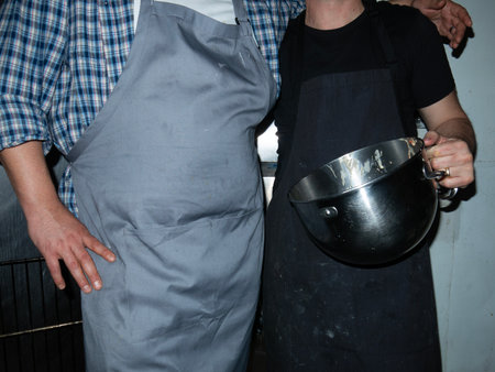 Close-up of a chef's hand holding a saucepan in the kitchenの写真素材