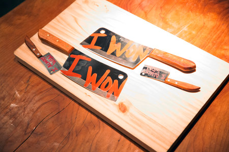 Knife set on a wooden cutting board with the inscription I wonの写真素材