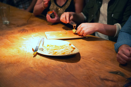 Group of friends having dinner together in a restaurant, sitting at a table, eating pizza