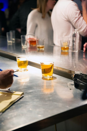 Barman pouring a pint of whiskey into a glass at a pubの写真素材