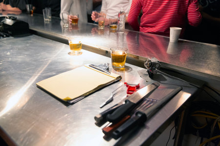 Bar counter with a glass of beer and a notepad on itの写真素材