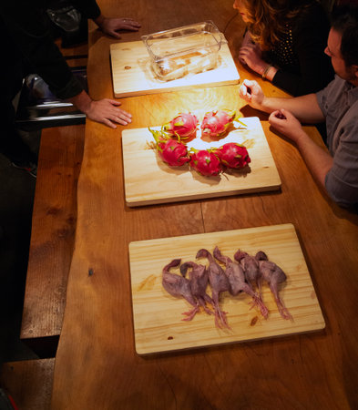 Unidentified people eating dragon fruit on wooden table.の写真素材