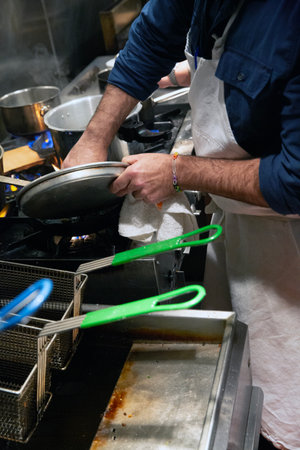 Chef preparing food in a restaurant kitchen, closeup of handsの写真素材