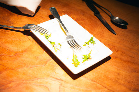 Restaurant table setting with plate and cutlery on wooden tableの写真素材