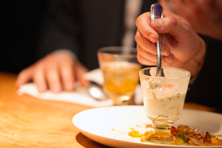 Close-up of a waiter serving a meal in a restaurant.の写真素材