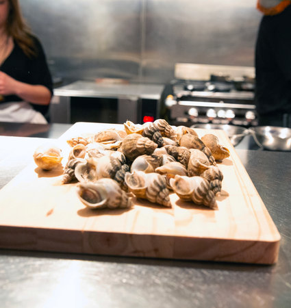Chef cooking oysters on a wooden board in a restaurant kitchenの写真素材