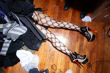 Female legs in stockings and fishnet stockings on wooden floorの写真素材