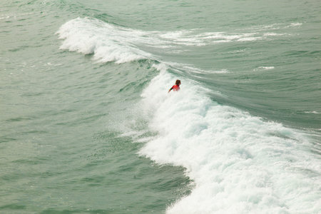 Surfer on the wave at Karon beach, Phuket, Thailandの写真素材