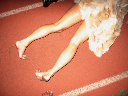 Legs of a woman in a fur coat on a running trackの写真素材