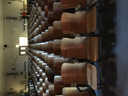 Rows of brown wooden chairs in a roomの写真素材