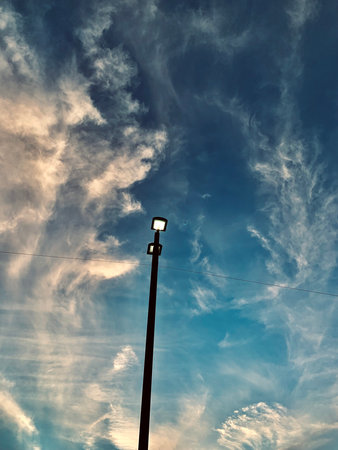 Street lamp against the blue sky with clouds. Filtered image.の写真素材