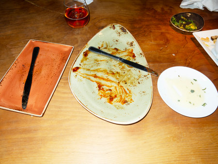 Empty plate with knife and fork on the table in a restaurant.の写真素材