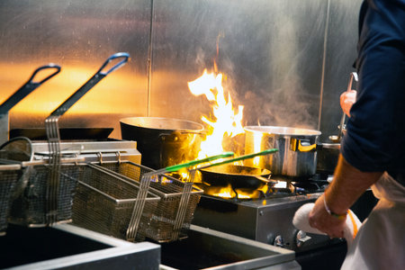 Chef at work in a restaurant kitchen. Chef at work, cooking foodの写真素材