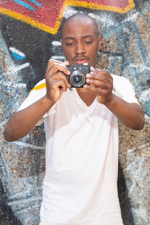 Portrait of a young african american man with a cameraの写真素材