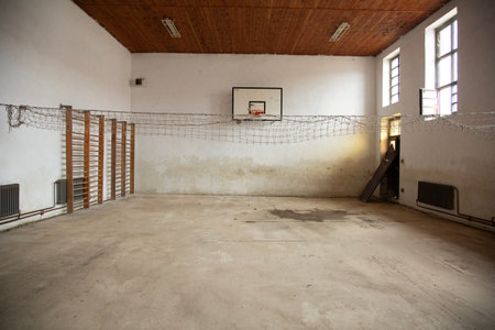Abandoned old school gymnasium with basketball hoop and barsの写真素材