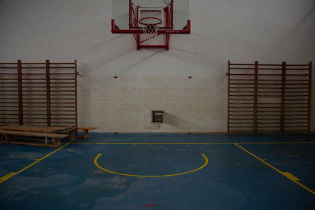 Interior of an empty basketball court with wooden bench and basketball hoopの写真素材
