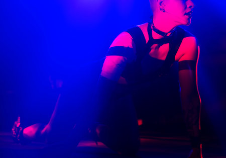 Young woman in a nightclub with red and blue lights. Close-up.の写真素材