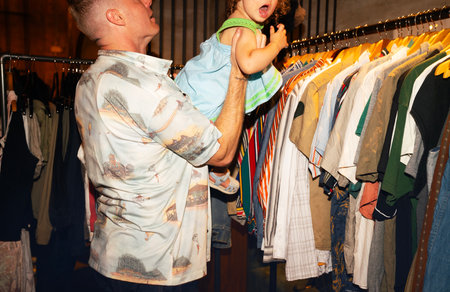 Dad and son choose clothes in the store. Dad helps his son choose clothes.の写真素材