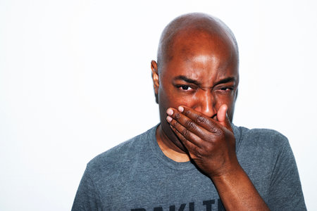 Young african man covering his mouth with his hand.の写真素材