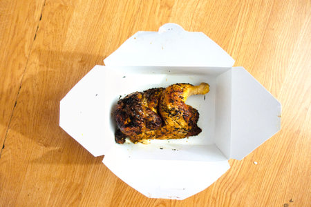 Grilled chicken in paper box on wooden background. Top view.の写真素材