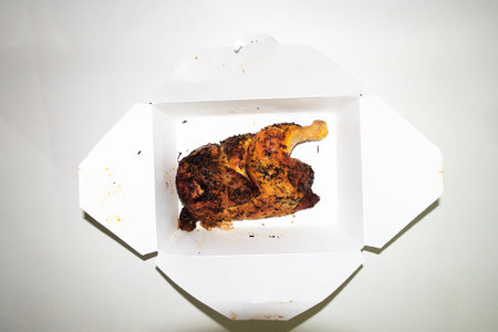 Roast chicken in a cardboard box on a white background, top viewの写真素材
