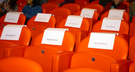 Rows of orange seats in a conference hall, waiting for the audienceの写真素材