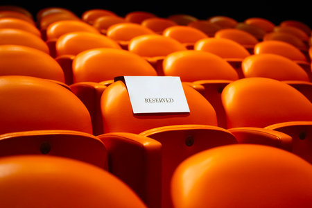 Empty orange seats in a theater with a white card for your textの写真素材