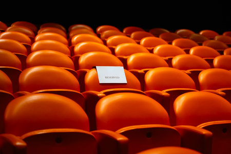 Empty seats in the auditorium of a theater or cinema with a blank piece of paper.の写真素材