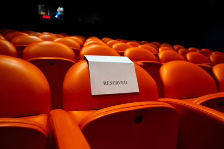 Empty cinema auditorium seats with a blank piece of paperの写真素材