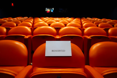 Rows of orange seats in a theater with a white board.の写真素材