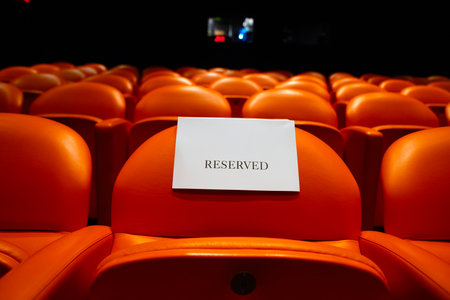 Cinema seats with a blank white card in a movie theaterの写真素材