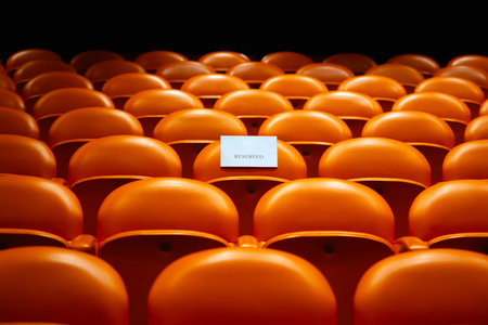 Orange plastic seats in a stadium or conference hall for sports and entertainment.の写真素材
