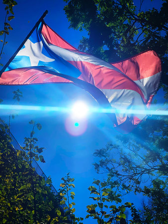 Flag of the Republic of Puerto Rico waving in the wind against the blue skyの写真素材