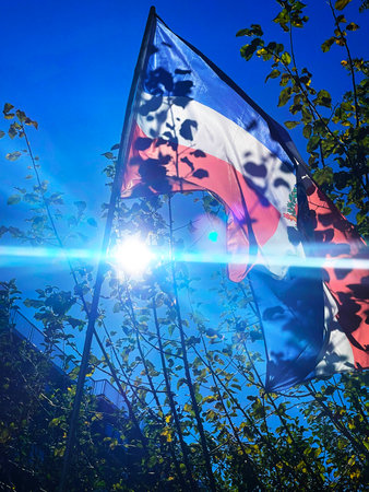 Flag of the Czech Republic against the blue sky and the sun raysの写真素材
