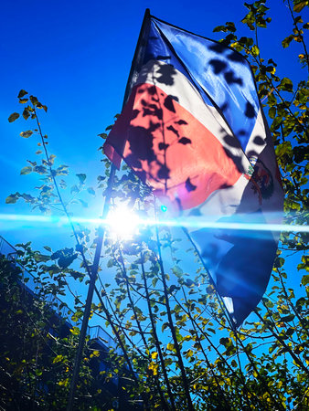 Flag of Dominican  Republic against the blue sky with sun rays and lens flareの写真素材