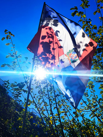 Conceptual image with the flag of the Dominican Republic against the blue skyの写真素材