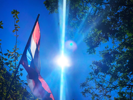 Flag of Thailand on the blue sky with sun rays and lens flareの写真素材