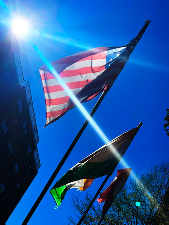 United States of America flags waving in the wind against blue sky.の写真素材