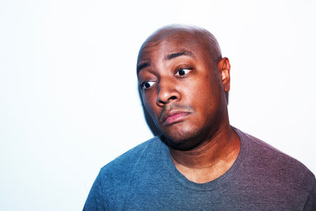 Portrait of a young black man looking at camera against white backgroundの写真素材