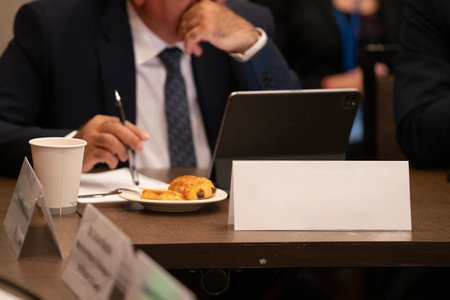 Businessman working on tablet computer at table in conference room, closeupの写真素材