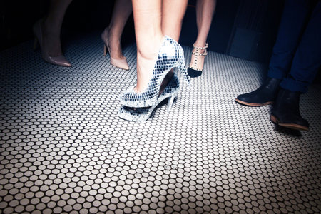 Beautiful legs of a young couple on the floor in a nightclub