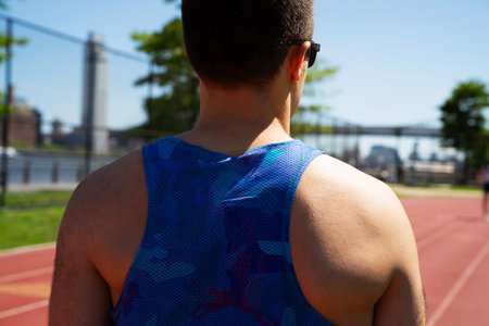 Rear view of a male athlete on a track and field.